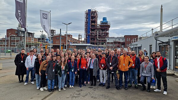 Gruppenfoto von Teilnehmern vor der Industrieanlage. Gruppenfoto vor Industriekulisse.